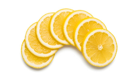 A collection of bright yellow lemon slices are fanned out in a curved arc on a white background,...の写真素材