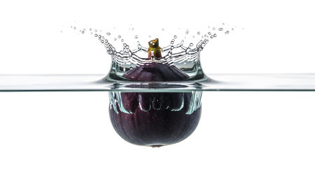 A deep purple fig causes a dramatic water crown splash and spreading ripples as it submerges in...の写真素材
