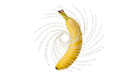 Droplets showing yellow banana with a vortex of water droplets swirling around it on a white...の写真素材
