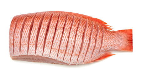 A whole red snapper fish is scored with a diamond pattern, showcasing its vibrant red scales and...