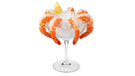 Cooked shrimp arranged around crushed ice in a crystal cocktail glass, topped with a lemon wedge.の写真素材