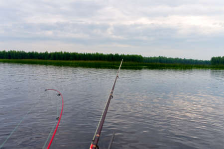 A fisherman on an inflatable boat catches fish on spinning. The process of trolling on the lake....