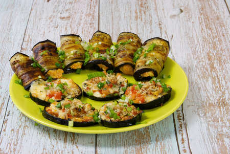 A festive snack of baked eggplant on a beautiful plate. Slices and rolls of vegetables with tasty filling. close upの写真素材