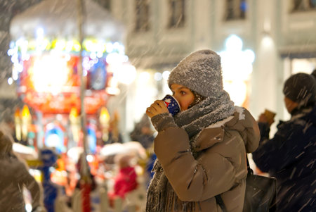 Young lady is drinking Mulled wine with spices outside in christmas market. close up