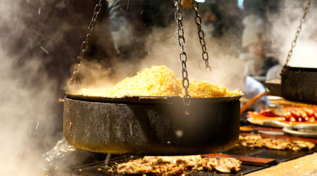 Street food is prepared at a Christmas market in the centre of Tallinn. Grilled sausages, fried...