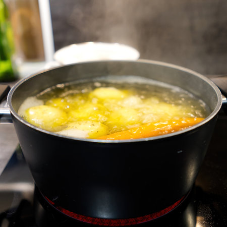 Pot of boiling water in which potatoes and carrots are boiled. close up