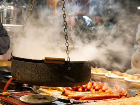 Street food is prepared at a Christmas market in the centre of Tallinn. Grilled sausages, fried cabbage and grilled meats. close upの写真素材