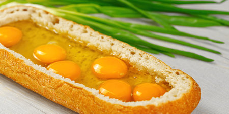 huge sandwich with raw eggs inside. Stuffed big ciabatta bread with raw ingredients ready to bake in...