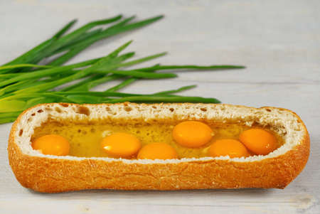 huge sandwich with raw eggs inside. Stuffed big ciabatta bread with raw ingredients ready to bake in...