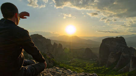 Man on the Top of Mountain at Sunset. Greece, Meteora. close upの写真素材