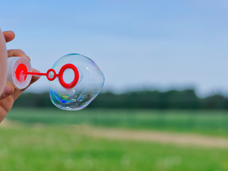 The child blows soap bubbles in nature. close upの写真素材