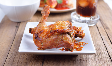 fried chicken on a white plate set on a wood tableの写真素材
