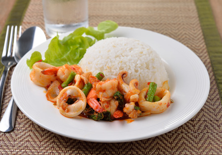 stir fried squid with chilli and basil on white plateの写真素材