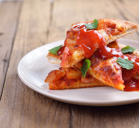 Hawaiian pizza With tomato sauce and mint leavesの写真素材