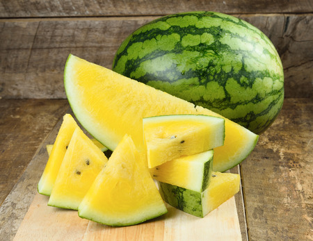 Yellow watermelon  sliced on wooden backgroundの写真素材
