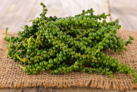 young  peppercorns on wooden  backgroundの写真素材