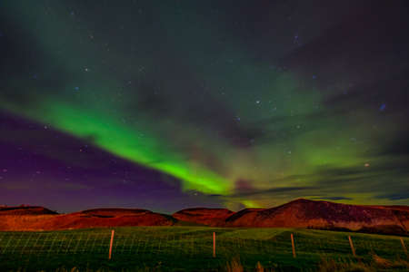 Northern lights Aurora borealis reflection across a lake in Iceland.の写真素材