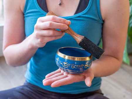 Haulerwijk - march 07 2020: Haulerwijk, The Netherlands. Close up shot of indian singing bowl in womans hand. Meditation and relax conceptのeditorial素材