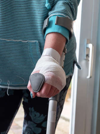 Injured woman trying to walk on Crutches at home.