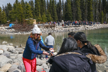 Lake Louise - May 20 2019: Lake Louise, Alberta, Canada. Girl taking a picture of a couple at Lake Louise, Alberta, Canadaのeditorial素材