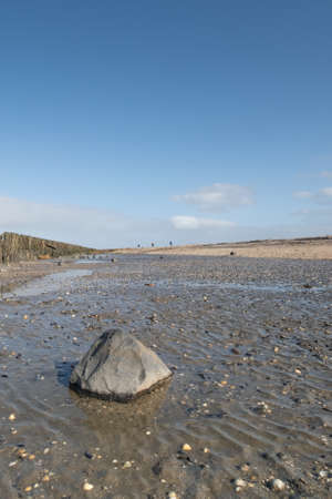 A soothing picture of the wadden sea at paesens moddergat, big rock in foreground, sea and sky.
