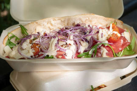 Lunch in nature, paper bag with sandwiches, coffee tea and orange juice are in front of the bag on the picnic bench. Recycling and environmentally friendly product concept. Take away foodの写真素材