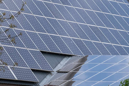 Two roofs with solar panel reflecting the clouds en trees. In the Netherlands.の写真素材