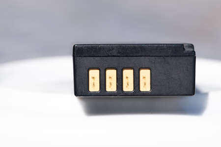 Battery for DSLR or system camera. Rechargeable on white with gray background. Space for your own...