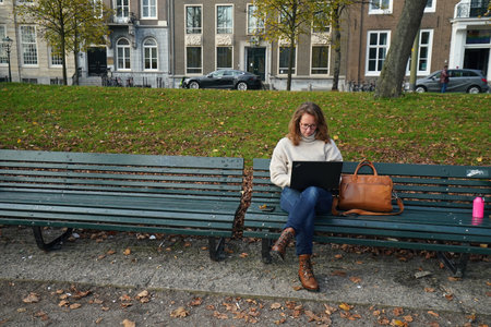 The Hague, November 10 The Hague, The Netherlands Young woman works in the park, during the Covid-19 pandemic. Distance and isolation in the city center of The Hague.のeditorial素材