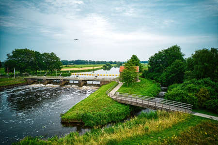 Drone view of the river the Vecht, beautiful blue sky and cycle path. Bridge and weir in the river. Flying drone in the sky. Dalfsen Netherlandsの写真素材