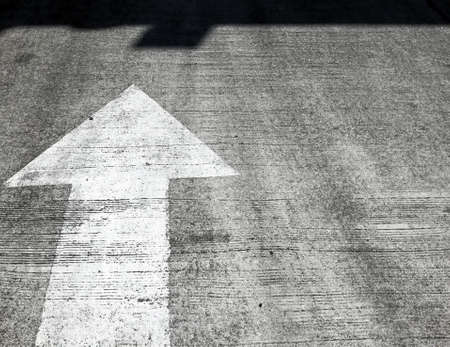 Arrow road sign point to the shadow.の写真素材