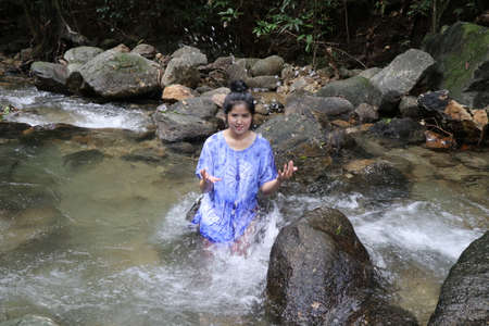 Woman are splashing water of the falls.の写真素材
