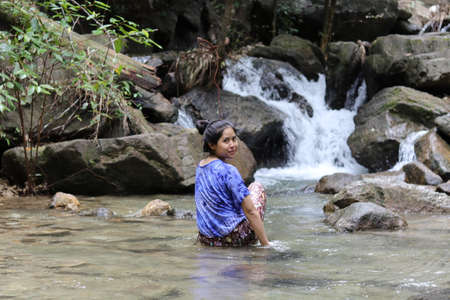 Woman looking back in waterfall.の写真素材