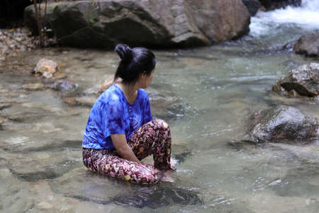 Women are thinking something In the waterfall.の写真素材