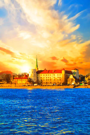 A beautiful view of the Riga Castle on the banks of the River Daugava in Riga, Latvia on a sunsetのeditorial素材