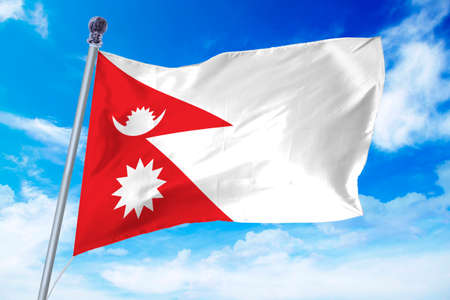 Flag of Nepal developing against a clear blue skyの写真素材
