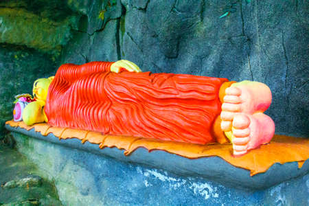 Statue of a lying sleeping Buddha in a stone cave in Sri Lankaの写真素材