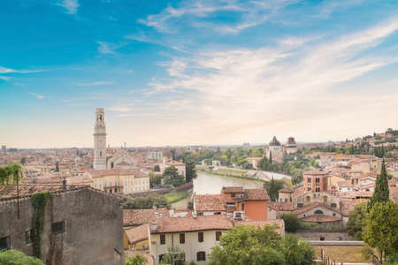 Beautiful view of the Lamberti Tower and Ponte Pietra on the banks of the Adige River in Verona,...