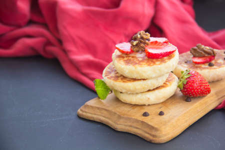 A healthy breakfast of pancakes, strawberries, chocolate, and honey