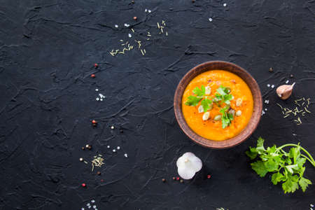 Delicious healthy pumpkin soup, herbs, and ingredients for the dish. Creative atmospheric decorationの写真素材