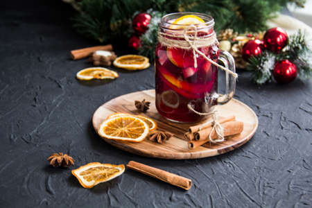 Christmas hot mulled wine with cinnamon cardamom and anise. Dark vintage dirty background. Creative atmospheric decorationの写真素材