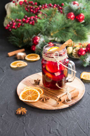 Christmas hot mulled wine with cinnamon cardamom and anise. Dark vintage dirty background. Creative atmospheric decorationの写真素材