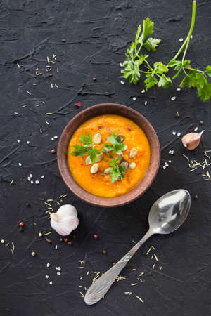 Delicious healthy pumpkin soup, herbs, and ingredients for the dish. Creative atmospheric decorationの写真素材