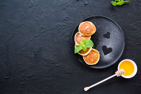 A healthy breakfast of cheese pancakes, berries, and honey. Creative atmospheric decorationの写真素材