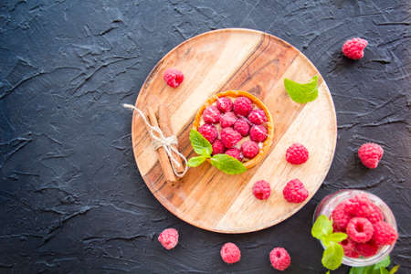 A healthy tasty dessert of cheese raspberry tart. Creative atmospheric decorationの写真素材