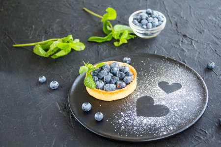 A healthy tasty dessert of cheese blueberry tart. Creative atmospheric decoration