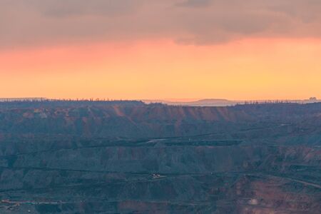 Beautiful bright sunset clouds above a working quarry. Distant viewの写真素材