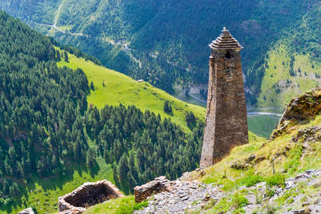Tusheti, Georgia: an ancient tower in an alpine village Kvavlo with a breathtaking aerial view of mountains and forests. Tusheti is an isolated mountainous region attracting most adventurous travelersの写真素材