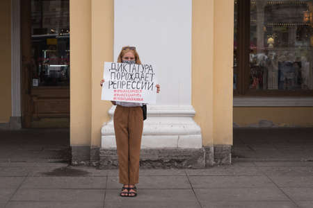Saint Petersburg, Russia - August 22, 2020: a protester holds a poster saying in Russian "Dictatorship Breeds Repression" with hashtags below supporting Navalny and democracy in Belarus and Khabarovskのeditorial素材