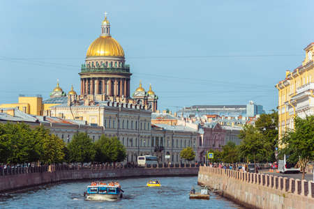 Saint Petersburg, Russia - August 18, 2019: St. Isaac's Cathedral and the old town houses along the Moyka River with a sightseeing boat.のeditorial素材